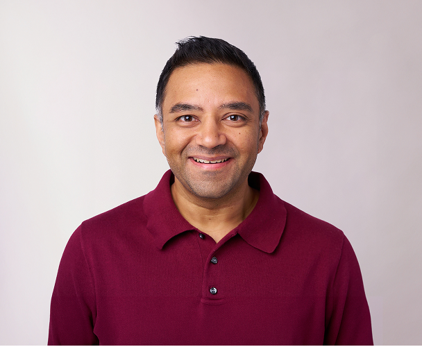 Headshot of Srinivas Somayajula, Chief Product Officer, wearing a red top.